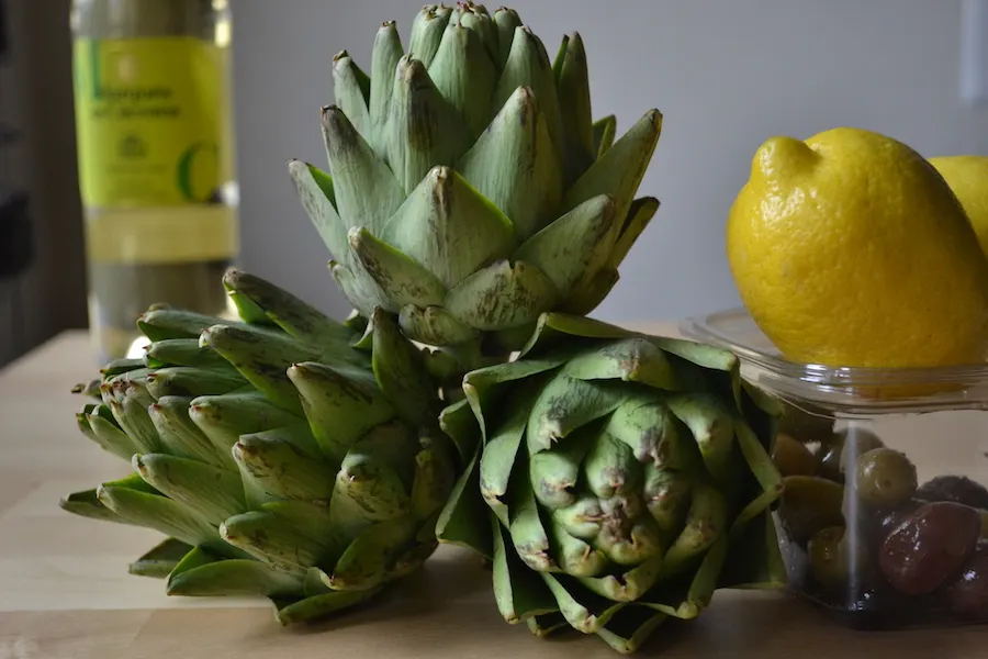 Break down artichokes and braise the hearts with wine and olives. Full recipe on BigTasteTinySpace.com