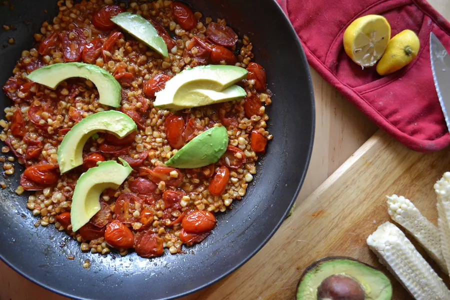 Top warm tomato and corn hash with slivers of cool silky avocado. Full reicpe on BigTasteTinySpace.com